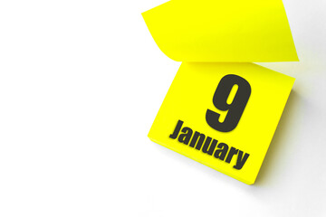 January 9th. Day 9 of month, Calendar date. Close-Up Blank Yellow paper reminder sticky note on...