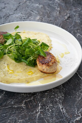 meat cutlet with mashed potatoes and microgreen of salad on a white plate
