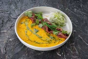 meat slices with mashed peas on a white plate
