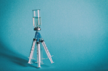 A bottle of medicine and five syringes sticking out of the bottle cap on a blue isolated...