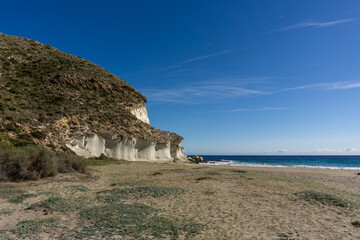 Fototapeta na wymiar small secluded sand beach framed by grassy hills on the Mediterranean coast of Andalusia near Cabo de Gata