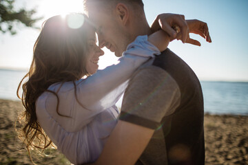 cheerful couple in love hugging in sunny weather