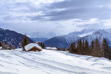 Fototapeta premium Alpine chalet sunk in deep snow in winter with thick snow on roof in the Swiss Apls, Switzerland
