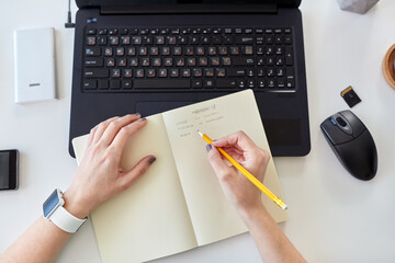 technology, post production and blogging concept - hands of young woman writing working plan to...