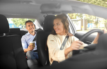 transportation, vehicle and people concept - happy smiling female driver driving car with male...
