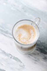 Coffee with milk on bright wooden background. Close up. Copy space.