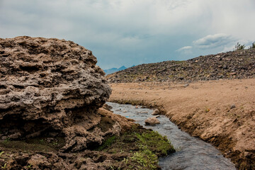 Fototapeta na wymiar A landscape with tiny rill flowing through the rocks