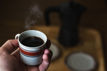 Coffee with smoke in a porcelain cup with unfocused background
