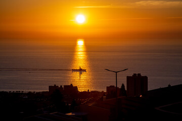 Fototapeta na wymiar sunset over the sea, a military ship is sailing on the sea.