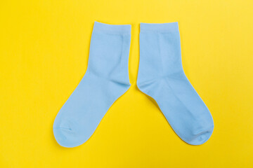 Top view of a pair of colored socks on a yellow background. Clothing in the form of socks.