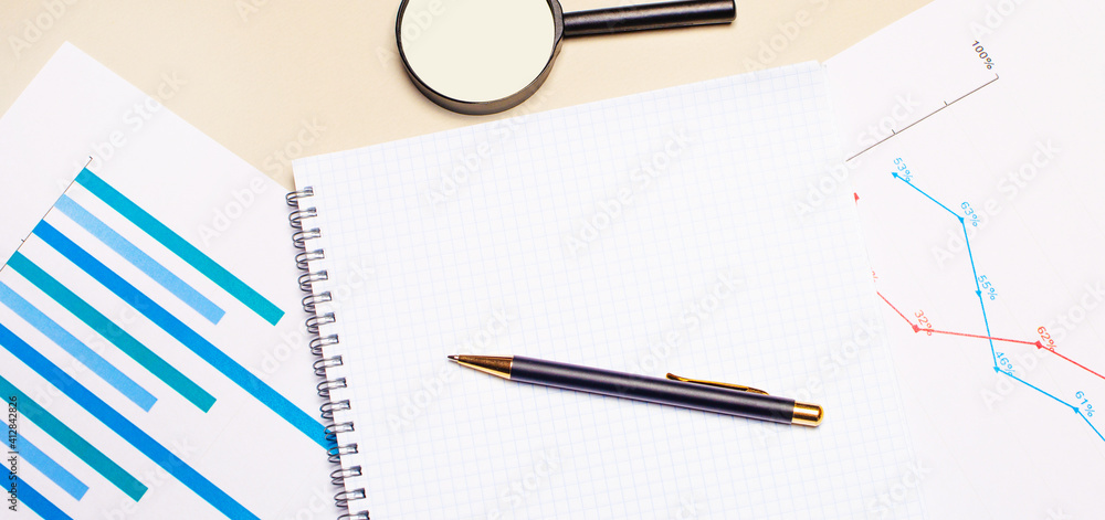 Poster on a light desktop, charts and reports, a magnifying glass, a pen and a blank notepad to insert text
