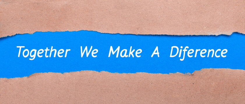 A strip of blue paper with the words TOGETHER WE MAKE A DIFFERENCE between the brown paper. View from above