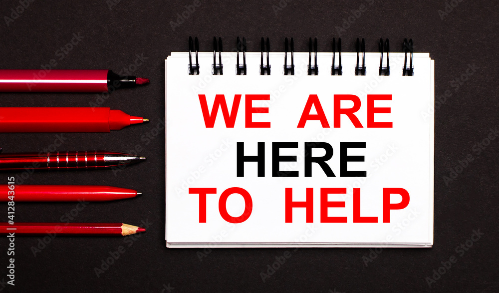Poster a white notepad with the text we are here to help, written on a white notepad next to red pens, penc