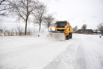 Räumfahrzeug auf schneebedeckter Straße im Winterdienst