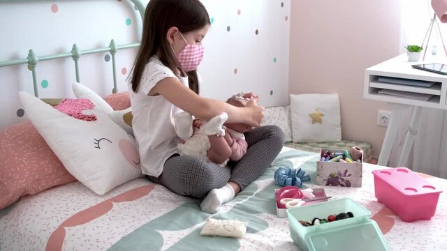 Girl with face mask putting small mask on her baby doll