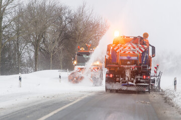 Räumfahrzeug auf schneebedeckter Straße im Winterdienst