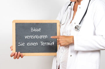 Hausärztin oder Fachärztin mit einer Tafel Bitte vereinbaren Sie einen Termin