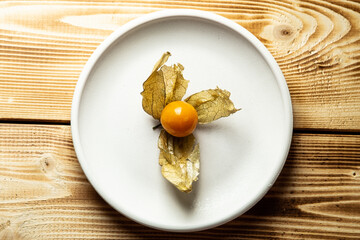berries and fisalis leaves on a wooden background