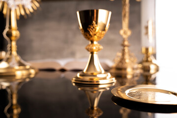 Catholic symbols composition. Religion concept. The Cross, monstrance,  Holy Bible and golden chalice gray background. 
