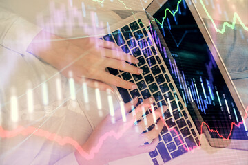 Double exposure of woman hands working on computer and forex chart hologram drawing. Top View. Financial analysis concept.