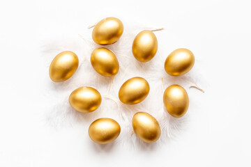 Golden Easter eggs with white feather. Top view decoration