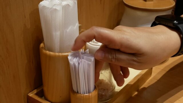 The motion of woman taking toothpick and napkin inside Japanese restaurant with 4k resolution.