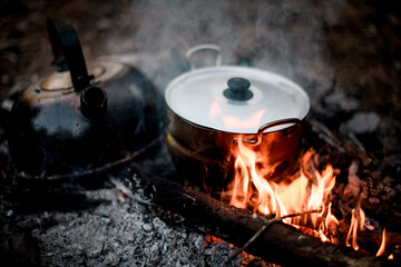 iron kettle and saucepan stands on the coals of fire