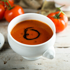 Homemade spicy tomato soup in a white bowl