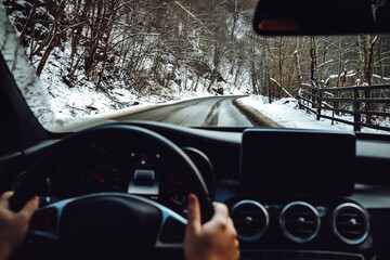 Portrait of man driving new modern car. details of winter roads and blurry dashboard