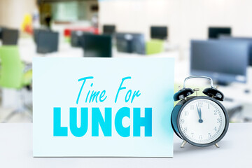 Close up of alarm clock with time for lunch text