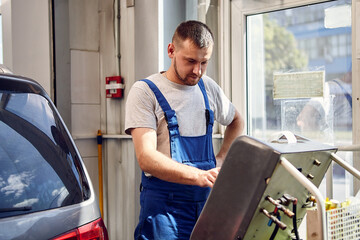 Mechanic checks air conditioning system in car auto service