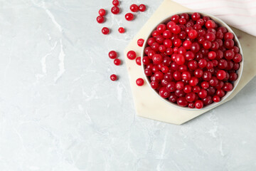Tasty ripe cranberries on light grey marble table, flat lay. Space for text