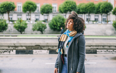 Dark skinned woman with afro hair on the street of a city