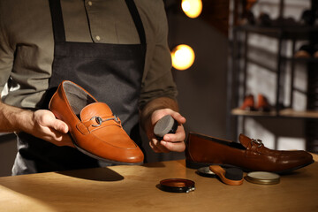 Master taking care of shoes in his workshop, closeup