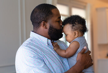 Loving father smiling and playing with his son at home.