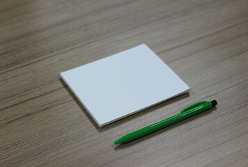 Sheet of paper with pen on wood background