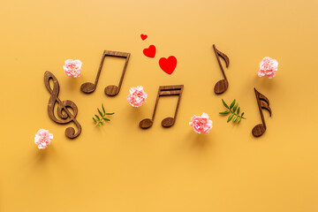 Musical wooden notes with flowers. Top view. Love songs concept