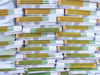 Lot of books stacked in layers in huge endless wall of knowledge. Industrial printing house. Book spines folded into stacks before trimming. Library background, typography, bookstore. Front view