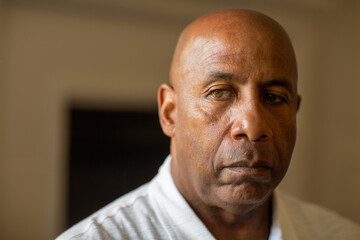 Senior African American man looking not smiling and looking depressed.