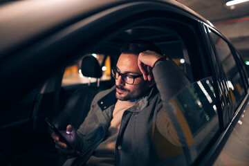 Handsome man using mobile phone in car