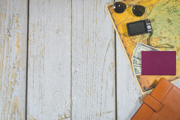 top view travel accessories. sunglasses, passport and foreign currency, photo camera, organizer agenda and world map. copy space. travel organization concept