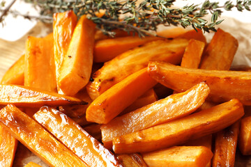 Fried sweet potatoes with thyme and spices close up