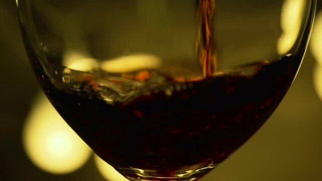 Pouring Wine into Wine Glass. Under Dramatic Low Key Lighting at Restaurant. Romantic Dinner Slow Motion Extreme Close Up Shot. B Roll.