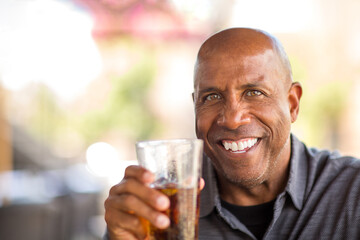 Mature African American man drinking at a restaurant.