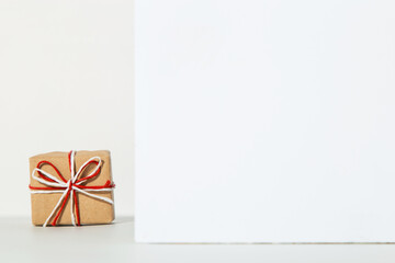 Kraft gift with a red ribbon on a white background, the concept of the Valentines day, congratulations.