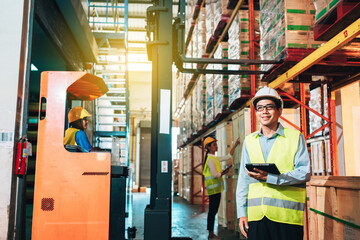 Working Team at warehouse. Manager use Tablet Information to further placement in storage department and asian woman warehouse workers.background driver at Warehouse forklift loader works with goods