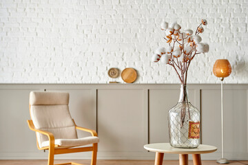 Cotton flower in the glass vase on the table, modern decorative wall room background style.