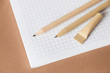 Reusable eco-friendly craft paper pen and pencil on the notebook. Writing ballpoint pen, environmental protection, ecology, natural materials, recycling concept