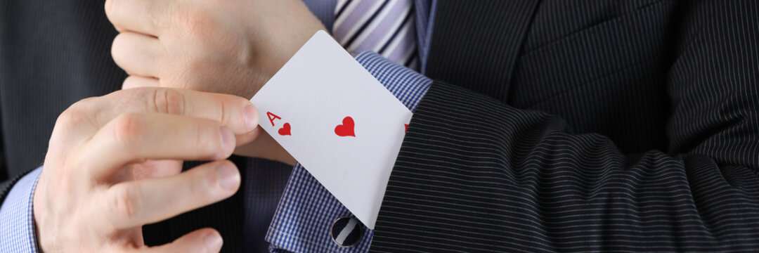 Man in suit puts ace of chirv card into sleeve of his jacket. Decisive secret business idea concept.
