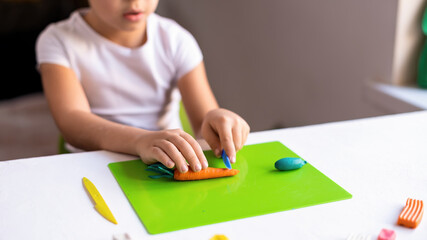 Small boy playing with plasticine